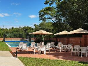a group of chairs and umbrellas next to a pool at Apartamento nuevo de 2 habitaciones cerca de Asunción 212 in Luque