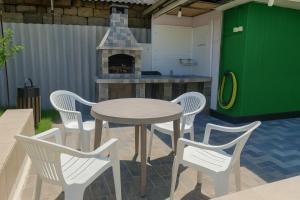 a patio with a table and chairs and a fireplace at Apartment Casa de Bruja in Drochia +9 photos
