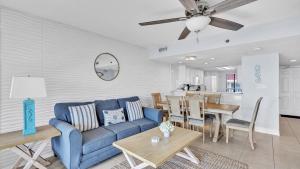 パナマ・シティ・ビーチにあるLow Floor - Remodeled - Beachfront - FLPCB65の青いソファのあるリビングルームとダイニングルーム