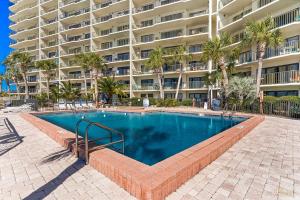 パナマ・シティ・ビーチにあるLow Floor - Remodeled - Beachfront - FLPCB65の大きなアパートメントの建物の前にスイミングプールがあります。