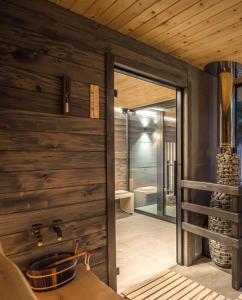 un bagno con pareti in legno e una porta scorrevole di La Tereza Apartments a Ķesterciems