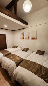 un grupo de cuatro camas en una habitación en Mina's SamuraiHouse, en Takayama