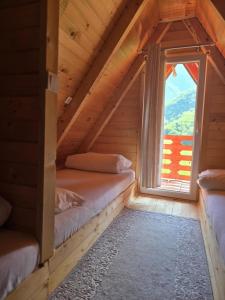una habitación con dos camas y una ventana en Ekoo katun Jezerca, en Vusanje