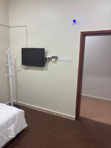 a room with a tv on the wall and a bed at فندق ثمريت in Thamarīt