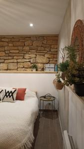a bedroom with a bed and a stone wall at La Tourelle - Gite et chambre d'hôte in Saint-Antonin