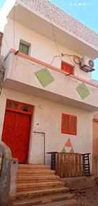 a house with red and green doors and stairs at هاي موود in Jazīrat Aswān