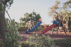 a playground with a red and blue slide in a park at Aventura Village in Potos