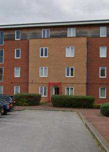 a brick building with a parking lot in front of it at 2 Bedroom by JL Airport & Retail in Liverpool