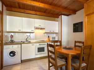 a kitchen with a table and a sink and a dishwasher at Apartamentos Lausan in Gavín +49 photos