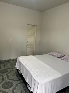 a bedroom with a large white bed in a room at Hotel paranatur in Pôsto Indígena Batovi