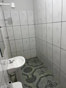 a white bathroom with a sink and a toilet at Hotel paranatur in Pôsto Indígena Batovi