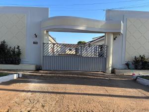 an entrance to a white house with a gate at Hotel paranatur in Pôsto Indígena Batovi