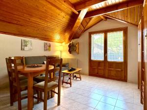 a living room with a wooden ceiling and a table at Apartamentos Lausan in Gavín