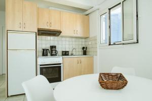a kitchen with a white table and white appliances at Sea Breeze Rooms in Armenistis