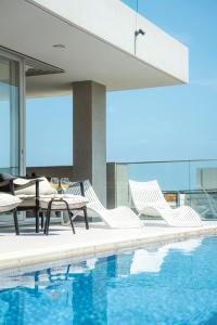 una piscina con sedie e un tavolo accanto all'acqua di Château Marine a Kamakura Altre 9 foto