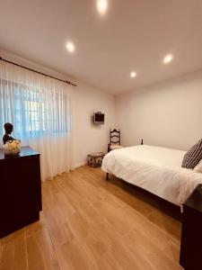 una camera da letto con un letto bianco e una finestra di CASA DOCE - Casa Rústica no Corotelo a São Brás de Alportel
