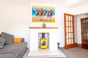 a living room with a fireplace with a painting on the wall at Beach Retreat Cottage- huge Garden Child & Dog friendly in Broadstairs