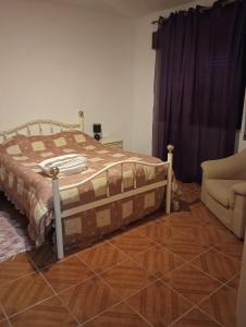 a bedroom with a bed and a couch and a chair at Casa das Lezírias in Unhais da Serra