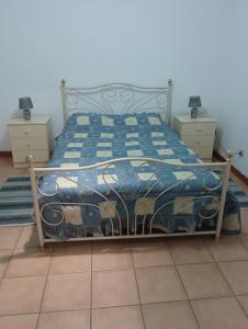 a bedroom with a bed with a blue and white comforter at Casa das Lezírias in Unhais da Serra