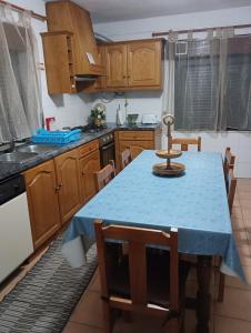 a kitchen with a blue table and wooden cabinets at Casa das Lezírias in Unhais da Serra +13 photos