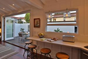 a kitchen with a counter and some stools in a room at The Cottage at West Beach by Paradise Retreats in Santa Barbara