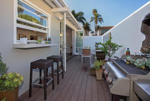 a balcony with stools and a table on a house at The Cottage at West Beach by Paradise Retreats in Santa Barbara