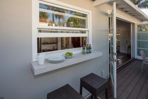 a window on the side of a house with plates and bottles at The Cottage at West Beach by Paradise Retreats in Santa Barbara +12 photos