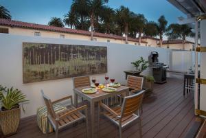 a patio with a table and chairs on a deck at The Cottage at West Beach by Paradise Retreats in Santa Barbara