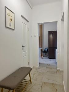 a living room with a bench and a hallway at Emerald - Modern Central Apartment in Tîrnăveni +9 photos