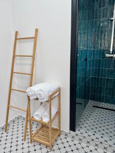 a bathroom with a ladder and towels on a tiled floor at Emerald - Modern Central Apartment in Tîrnăveni