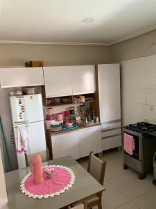 a kitchen with a table with a pink cake on it at Casa para COP30 in Ananindeua