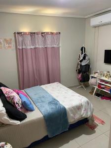 a bedroom with a bed and a pink curtain at Casa para COP30 in Ananindeua