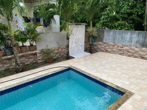 a swimming pool in a backyard with a brick wall at Casa para COP30 in Ananindeua