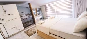 a bedroom with a large white bed and a mirror at Arcadia homes avsallar in Alanya +143 photos