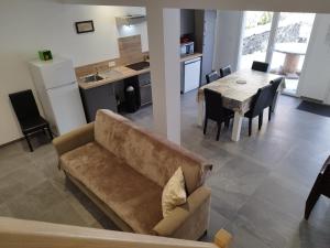 a living room and kitchen with a couch and a table at Gîtel'harmonie2 in Fraize