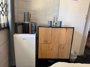 a small refrigerator next to a small wooden cabinet at Ladybird in Durban