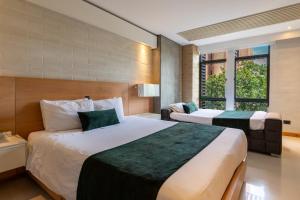 a hotel room with two beds and two windows at Terra Biohotel in Medellín