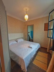 Un dormitorio con una gran cama blanca en una habitación. en White House, en Mirleft