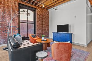 Una sala de estar con un sofá y un televisor. en Sunny & Spacious Loft - Perfect for Work and Play!, en Saint Louis