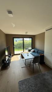 a living room with a blue couch and a table at Modern Apartment - Lund in Kristiansand
