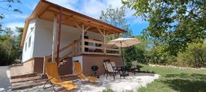 a house with a table and chairs and an umbrella at Hilltop Cottage in Szentendre, mountain view, terrace, garden in Szentendre