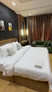a bedroom with a large white bed and a couch at Paradise away from Home in Lekki