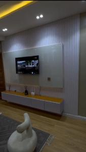 a living room with a tv and a white chair at Paradise away from Home in Lekki