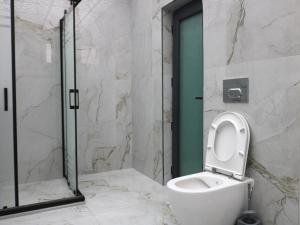 a bathroom with a toilet and a glass shower at Çalışkan Otel in Havza