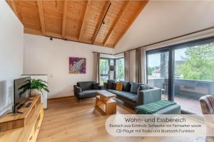a living room with a couch and a tv at INVITA Natur-Chalets - Gruppenurlaub, Events im Schwarzwald - 6 Apartments, 25 Personen in Bad Dürrheim