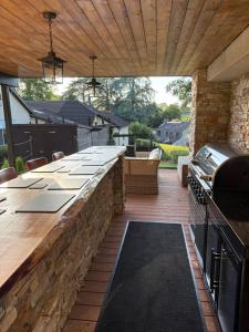 an outdoor kitchen with a long bar with a stone wall at Luxury property - Swimming Pool, Games Room & Hot Tub in Usk