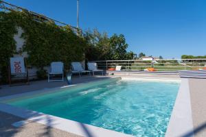 a swimming pool with two chairs and a table at bed&breakfast Filomare in Numana