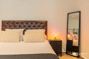 a bedroom with a large bed and a mirror at Petit Paradis - Terrasse privée - 100m de la gare in Hénin-Beaumont