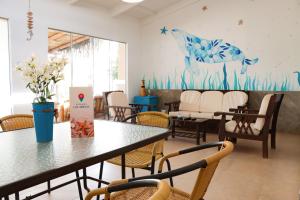 a waiting room with tables and chairs and a mural at ÓRGANOS BEACH bungalows & suites in Los Órganos