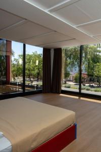 a bedroom with a large bed and large windows at Hotel WW in Mérida